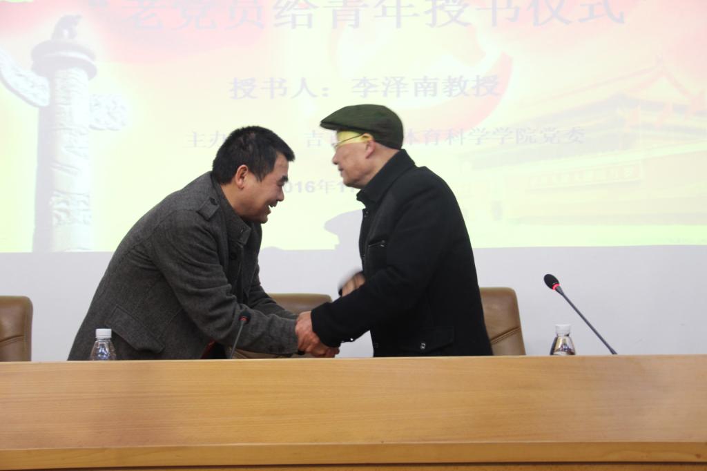 图为肖书记与李教授握手(张成兵摄)